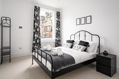 a bedroom with a black and white bed and a window at River Street View in Bath