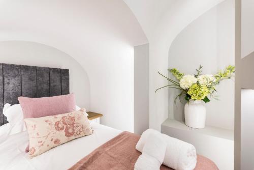 a bedroom with a bed and a vase of flowers at Wine Vaults Apartment in Bath