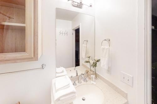 a white bathroom with a sink and a mirror at Riverfront Retreat in Nashville