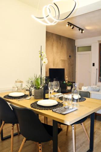 a dining room table with plates and wine glasses at Evo Residence Taietura Turcului in Cluj-Napoca