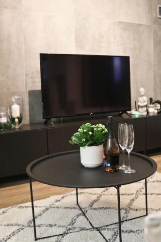 a table with a potted plant and two wine glasses at Evo Residence Taietura Turcului in Cluj-Napoca