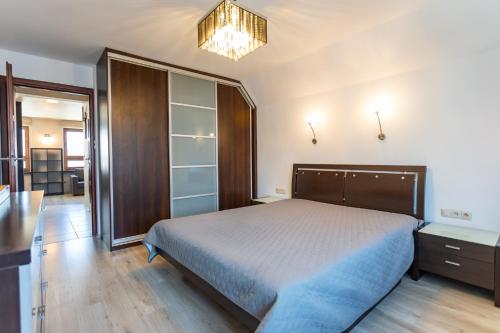 a bedroom with a large bed and a chandelier at Apartament w Sercu Miasta in Elblag