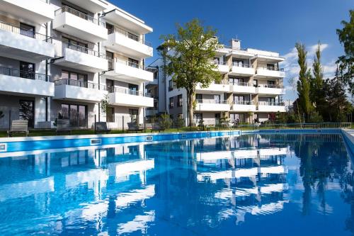 una piscina di fronte a un edificio di SandLand - Rezydencja Ustronie Morskie - Apartamenty a Ustronie Morskie