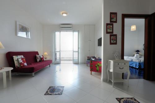 a living room with a red couch and a table at Due Relais - Panoramic Sea View Suites in Vietri sul Mare
