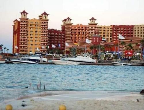 a large body of water with boats in a city at sea view apartment in Porto Marina hotel tower in El Alamein