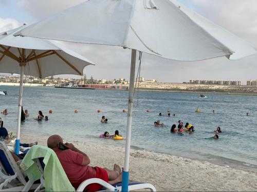 a group of people in the water at a beach at sea view apartment in Porto Marina hotel tower in El Alamein