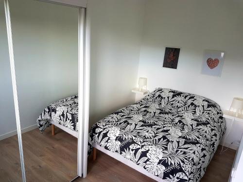 a bedroom with a bed and a mirror at Appartement rénové lumineux proche centre ville in Louviers