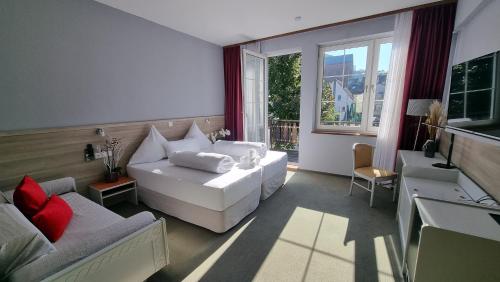 a living room with a white couch and a window at MATZ Brunnenhof in Wilgartswiesen