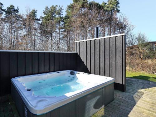a hot tub sitting on a deck with a fence at 8 person holiday home in L s in Læsø