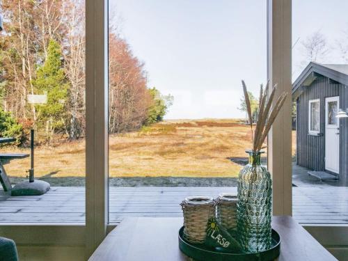un jarrón sentado en una mesa frente a una ventana en 4 person holiday home in L s en Læsø