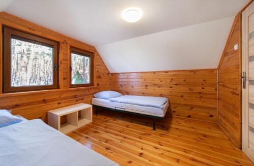 LubiatówにあるSława Family Resortのベッド2台とベンチが備わる客室です。