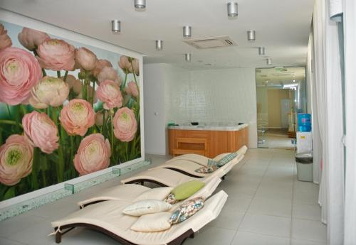 a hospital room with four beds with pink flowers on the wall at Admiral Plaza Holiday Apartments in Sunny Beach