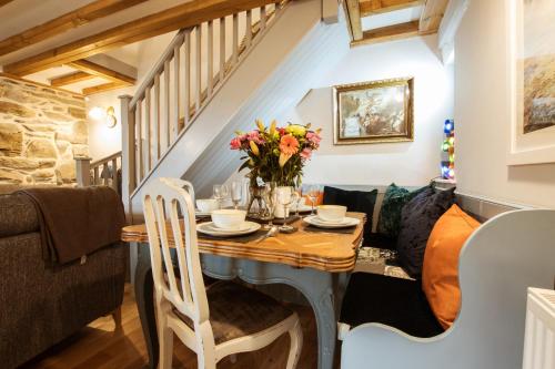 a dining room with a table with flowers on it at Cosy, coastal cottage in Snowdonia in Harlech