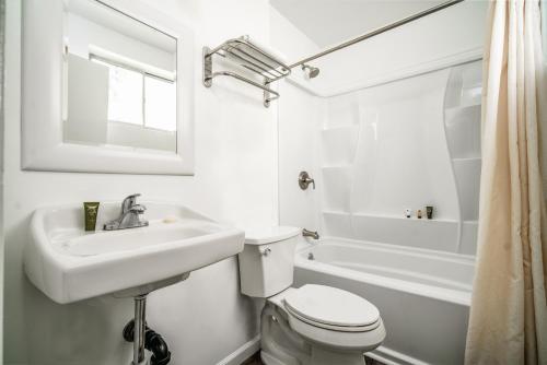 a white bathroom with a sink and a toilet at Hollywood Downtowner Inn in Los Angeles
