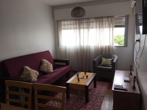 a living room with a purple couch and a table at Department Pancho Olivar in Mendoza