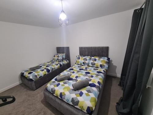 two beds in a room with curtains at 6 Bed sleeps 7, 1 mile from M54 i54 Jaguar Land Rover MOOG in Wolverhampton