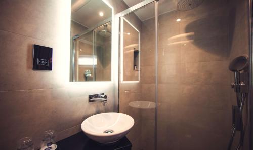 a bathroom with a toilet and a sink and a shower at Best Western Plus Delmere Hotel in London