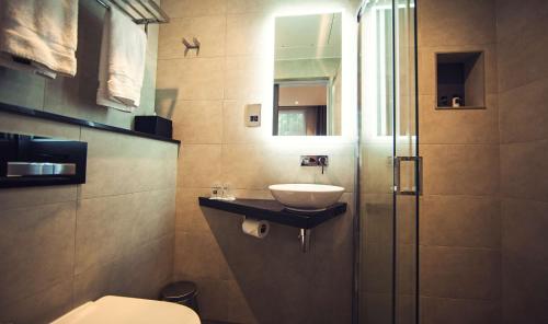 a bathroom with a sink and a toilet at Best Western Plus Delmere Hotel in London