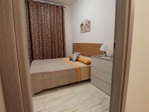 a small bedroom with a bed and a dresser at Villa Silvana-Fronte Mare in Marsala