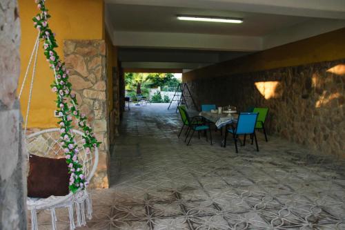 a dining room with a table and chairs and a stone wall at Villa Silvana-Fronte Mare in Marsala