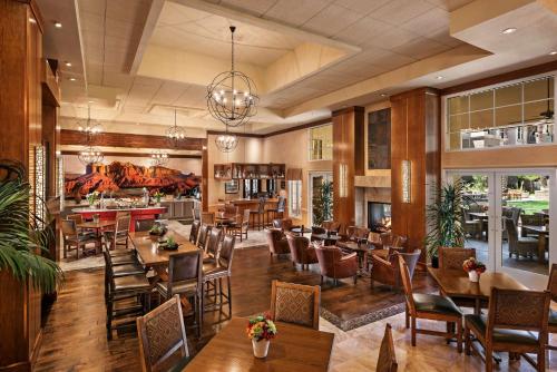 a restaurant with tables and chairs and a bar at Sonesta Suites Scottsdale Gainey Ranch in Scottsdale