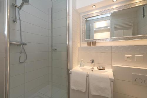 a bathroom with a shower and a sink and a mirror at Haus-am-Meer14-App-129-WB in Westerland