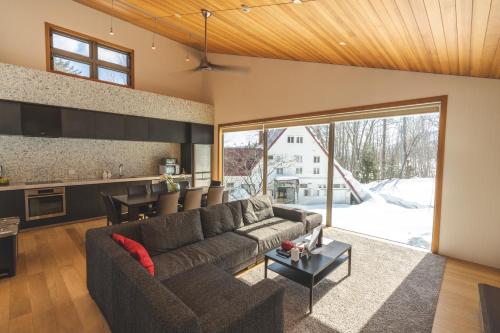 a living room with a couch and a table at SOLAR CHALETS by Hakuba Hotel Group in Hakuba