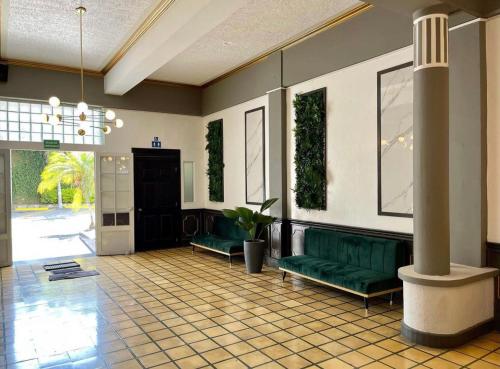 a lobby with two green couches in a building at Kali Hotel in Santa Ana