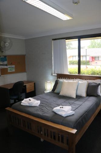 a bedroom with a large bed with towels on it at Western Sydney University Village - Hawkesbury in Richmond