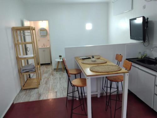 una pequeña cocina con mesa y taburetes. en Moroty en Posadas