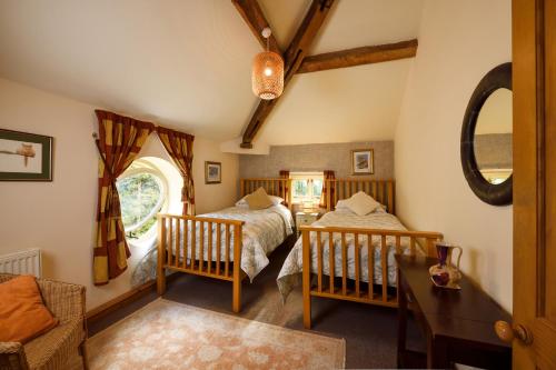 a bedroom with two beds and a table at The Coach House in Oswestry