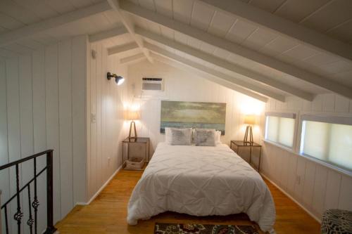 a bedroom with a bed with white sheets and two lamps at Peaceful Getaway in Studio City in Los Angeles