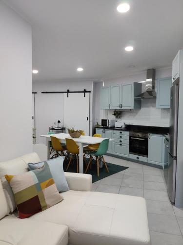 a living room with a white couch and a kitchen at Riviera Beach AL in Praia da Vitória