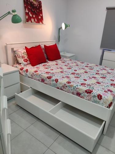 a bedroom with a bed with red pillows on it at Riviera Beach AL in Praia da Vitória