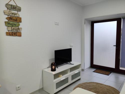 biały salon z telewizorem i oknem w obiekcie Riviera Beach AL w mieście Praia da Vitória