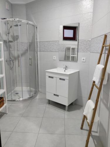 a white bathroom with a shower and a sink at Riviera Beach AL in Praia da Vitória