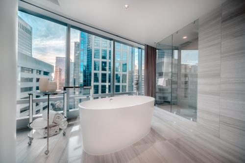 a large bathroom with a tub and a large window at Paradox Hotel Vancouver in Vancouver