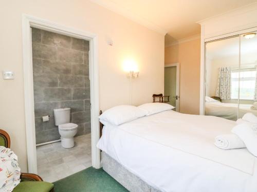 Un dormitorio con dos camas y un baño. en The Doves, en Bridport