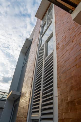 a brick building with a window shutter on it at Tuju WK Homes Syariah in Jakarta