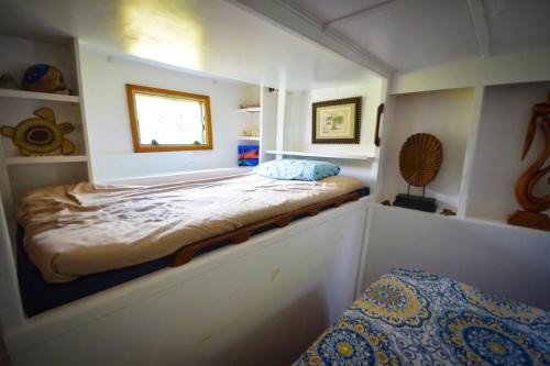 a small bedroom with a bed in a room at Queen Malesso Houseboat in Merizo