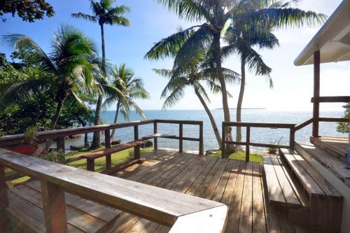 a wooden deck with a view of the beach at Queen Malesso Houseboat in Merizo