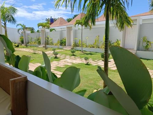 a backyard of a house with palm trees and a fence at Pineale Villas, Resort and Spa in Panglao