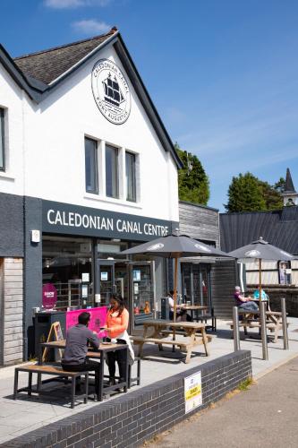 two people sitting at tables in front of a building at The Caledonian Hotel in Fort William
