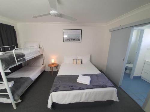 um quarto com um beliche e uma escada em Sun City Motel em Bundaberg