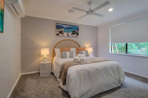 um quarto com uma cama com 2 candeeiros e uma janela em Coastal 3-bedroom home close by the beach em Port Macquarie