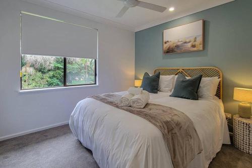 um quarto com uma cama grande e uma janela em Coastal 3-bedroom home close by the beach em Port Macquarie