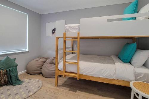 a bedroom with a bunk bed with a ladder at Coastal 3-bedroom home close by the beach in Port Macquarie