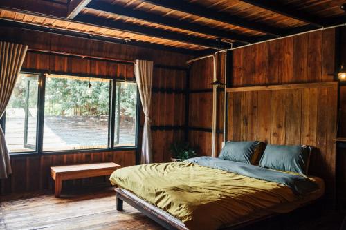 sypialnia z łóżkiem w pokoju z drewnianymi ścianami w obiekcie Villa Đảo Hoa Vàng Cam Ranh - Venuestay w mieście Cam Ranh