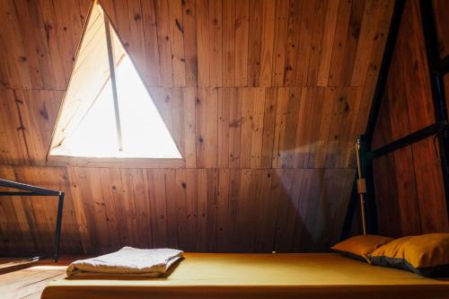a room with a bed with a window in a wooden wall at Villa Đảo Hoa Vàng Cam Ranh - Venuestay in Cam Ranh