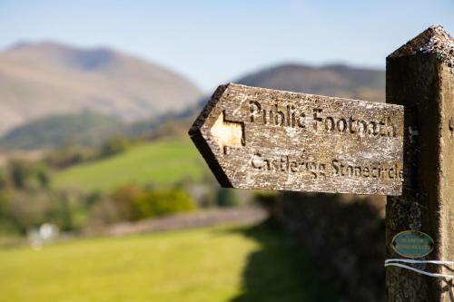 a sign on a fence with mountains in the background at The Derwentwater Hotel in Keswick